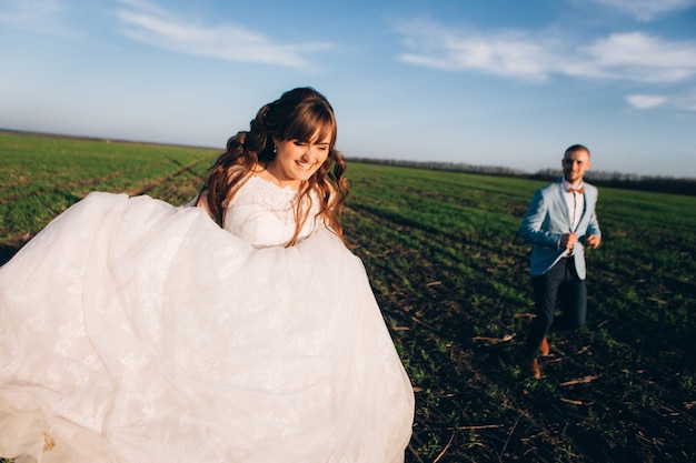 Elegante sposa e sposo che propongono insieme all'aperto in un giorno di nozze