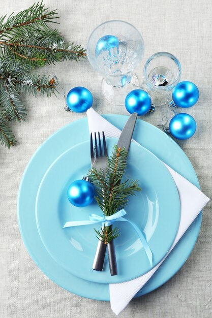 Elegante tavola di Natale blu e bianca sulla superficie della tovaglia grigia