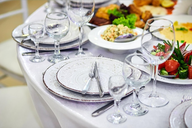 Elegante tavola nei toni del beige bianco pronta per l'arrivo degli ospiti Bellissimi piatti all'interno del ristorante