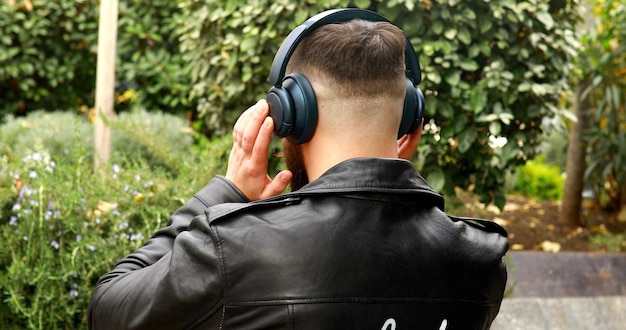 Elegante uomo barbuto in cuffia che ascolta la musica.