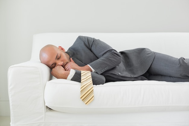 Elegante uomo d&#39;affari che dorme sul divano