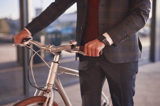 Elegante uomo d'affari con la bicicletta su strada