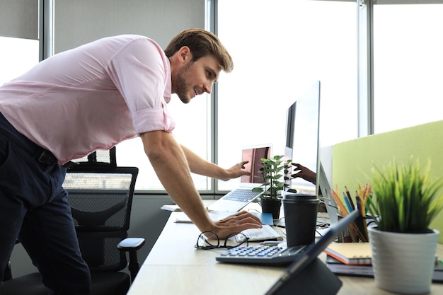 Elegante uomo d'affari moderno che analizza i dati mentre si lavora in ufficio.