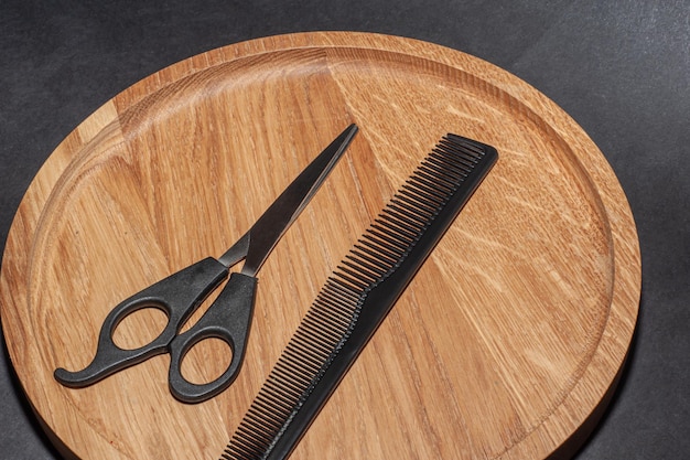 Eleganti forbici da barbiere professionali, taglio di capelli su fondo di legno.