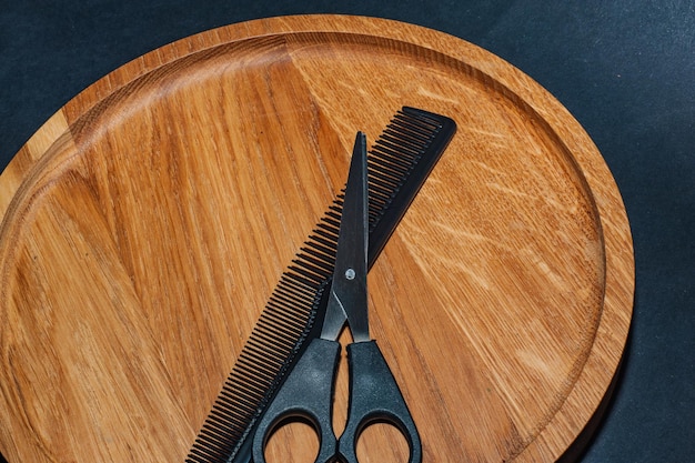 Eleganti forbici da barbiere professionali, taglio di capelli su fondo di legno.