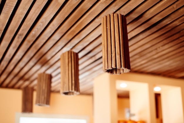 Eleganti lampade in legno di design sul soffitto. Interni moderni, materiali naturali