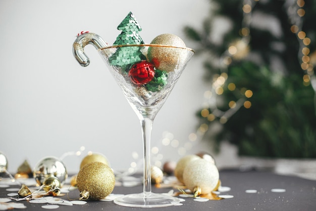 Eleganti ornamenti natalizi lucidi e albero in bicchiere di champagne e palline d'oro Festa di Capodanno