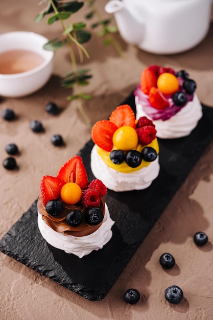 Eleganti pavlovas di frutta su un vassoio di ardesia