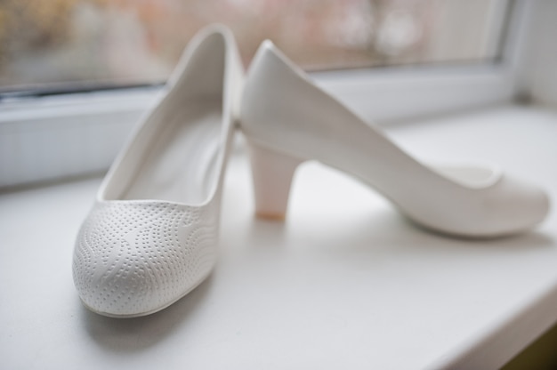 Eleganti scarpe bianche da sposa alla mattina della sposa.