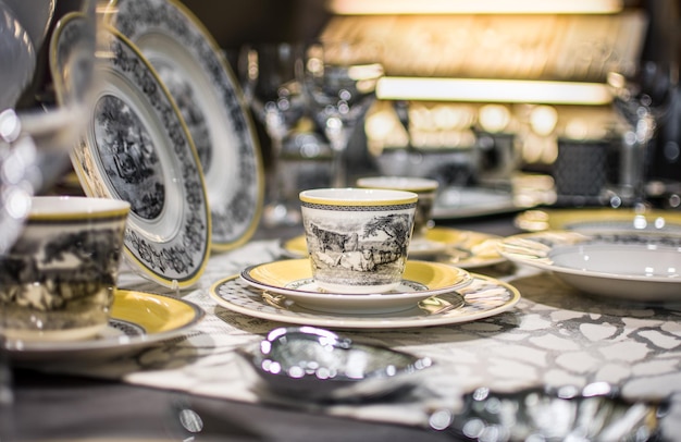 Eleganti stoviglie di lusso e piatti in porcellana in colore bianco e dorato sul tavolo per il matrimonio.