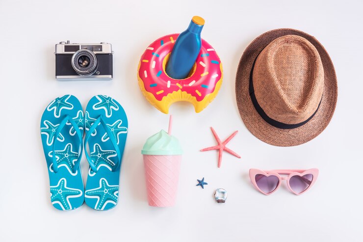 Elementi degli accessori di viaggio su fondo bianco, concetto di vacanze estive