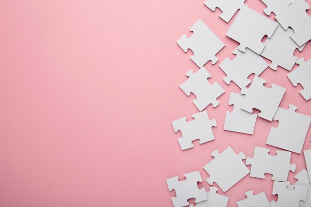 Elementi incompleti di un puzzle bianco su sfondo rosa Spazio per il testo