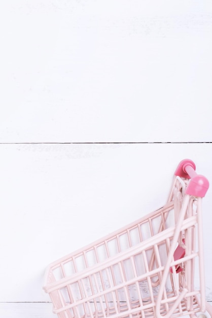 Elemento di design astratto vendita annuale stagione dello shopping concetto mini carrello con sacchetto di carta colorato su sfondo bianco tavolo in legno vista dall'alto laici piatta
