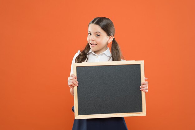 Elenco delle attività. scrivere compiti a casa. di nuovo a scuola. buona giornata degli insegnanti. 1 settembre. piccola ragazza dimostrare annuncio. felice piccola ragazza della scuola con la lavagna. lavagna per copia spazio. informazione.