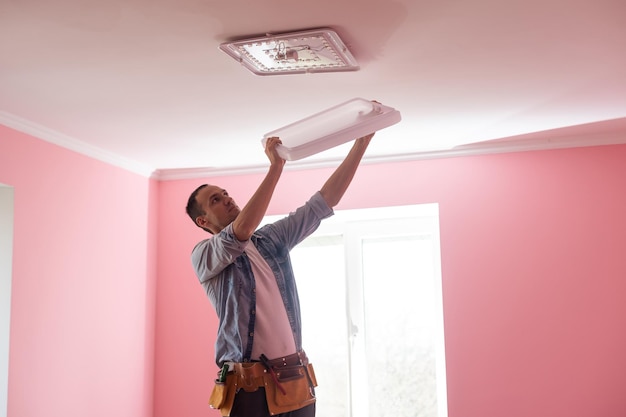 Elettricista che installa una luce a led sul soffitto.