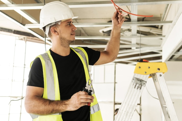 Elettricista che taglia i fili durante il suo lavoro