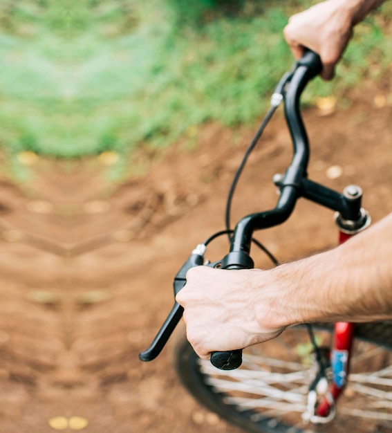 Elevato angolo delle mani sul manubrio della bicicletta Vista laterale delle mani sul manubrio della bicicletta Concetto delle mani del ciclista sul manubrio