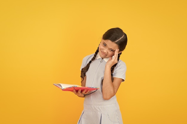 Emicrania Libro di lettura bambino carino su sfondo giallo Bambina adorabile impara a leggere lo spazio della copia Lettura e scolarizzazione a casa Studio duro Esame in arrivo Test finale Argomento difficile