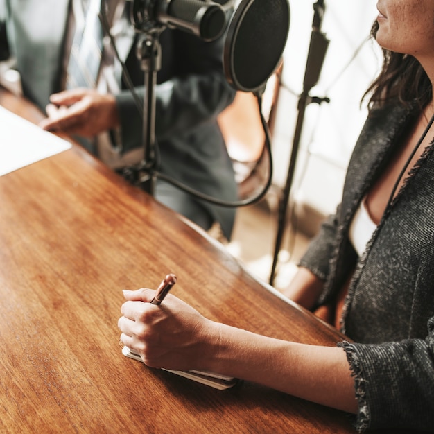 Emittente femminile che intervista il suo ospite in uno studio