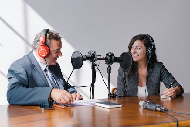 Emittente femminile che intervista il suo ospite in uno studio