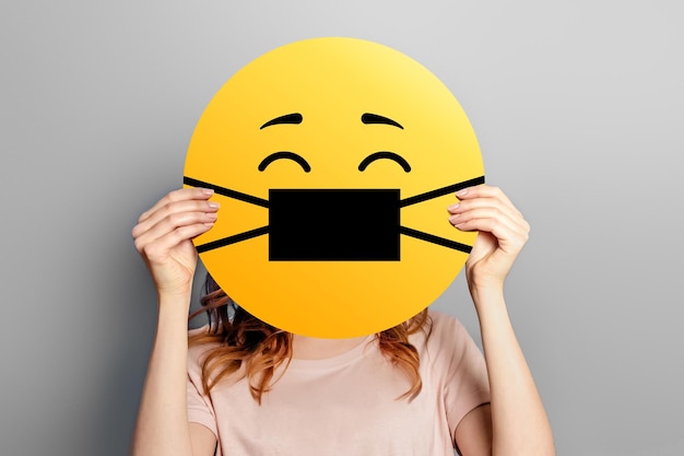 Emoticon con maschera facciale medica Faccina gialla spaventata in una goccia di medicina