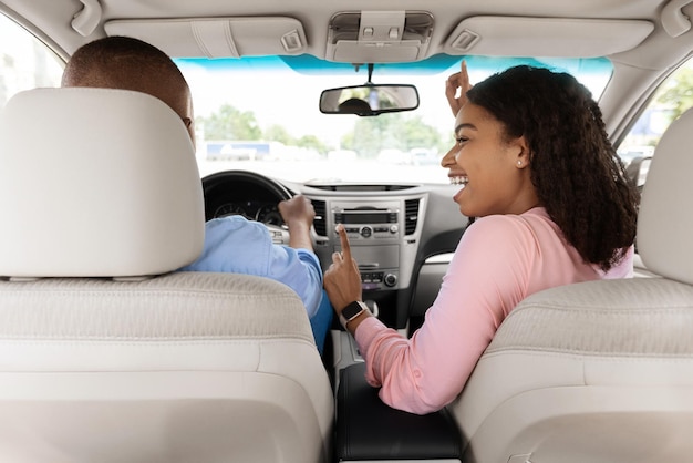 Emozionante coppia nera che si gode la musica alla guida di un'auto di lusso