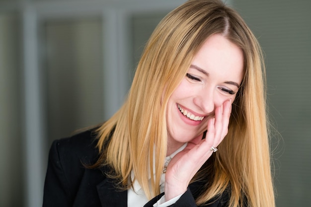 Emozione faccia felice sorridente allegro donna felice affari signora al lavoro in ufficio giovane bella ragazza bionda ritratto