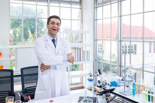 Emozioni di scherzo pazze divertenti positive e gioiose Ritratto di scienziato fiducioso di scienziato maschio felice che tiene le braccia incrociate nello scienziato di laboratorio di chimica che tiene la provetta con il campione nell'analisi di laboratorio