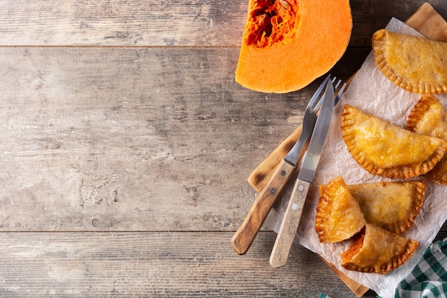 Empanadillas di zucca su tavola di legno