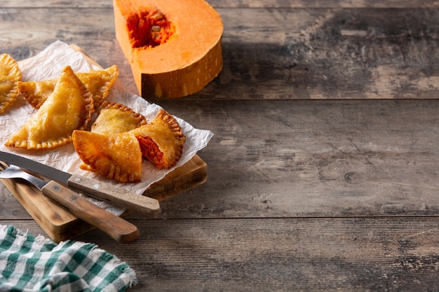 Empanadillas di zucca su tavola di legno