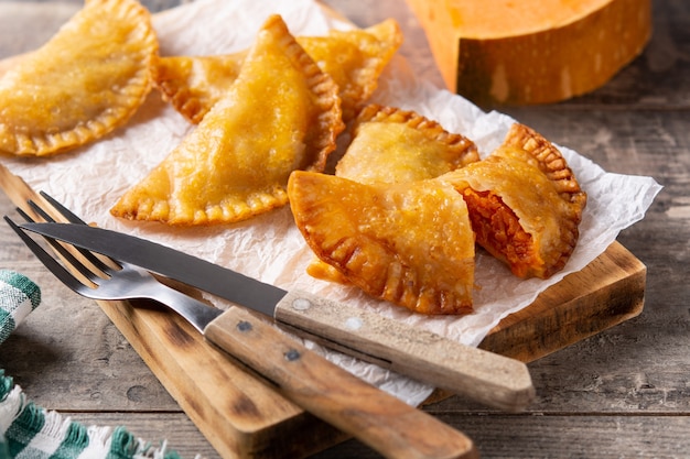 Empanadillas di zucca su tavola di legno