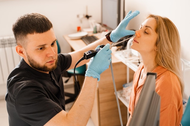 Endoscopia del naso Procedura di rinoscopia con rinoscopio Otorinolaringoiatra otorinolaringoiatra con trattamento fari naso donna paziente