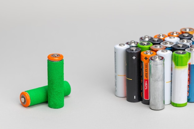 Energia verde in una batteria elettronica Batterie ordinarie e una batteria verde fatta di erba