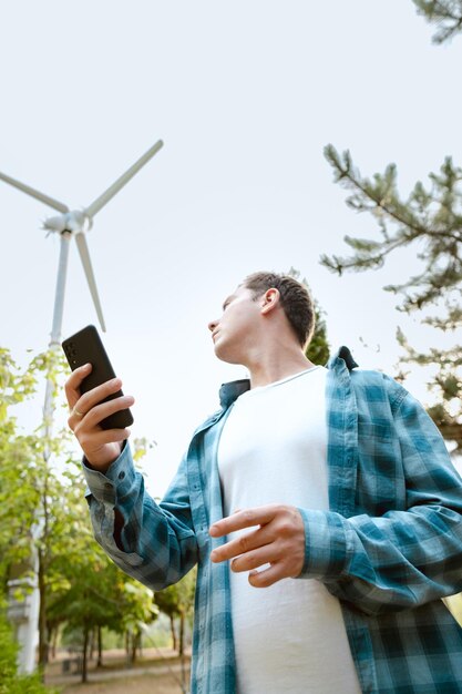 Engineer with a phone considering climatic and geographic factors for optimal turbine performance