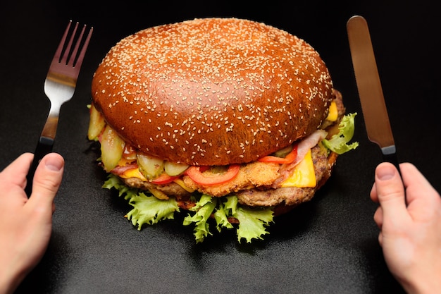 Enorme grande hamburger gigante su un primo piano superficie scura