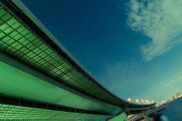 Enorme struttura autostradale che va lontano sopra le acque del fiume notturno a Tokyo, Giappone