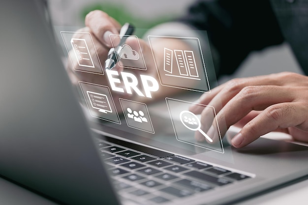 Enterprise Resource Planning (ERP) è un sistema software di pianificazione delle risorse aziendali. Su uno schermo virtuale, c'è il concetto di una mano che digita le icone del computer portatile.