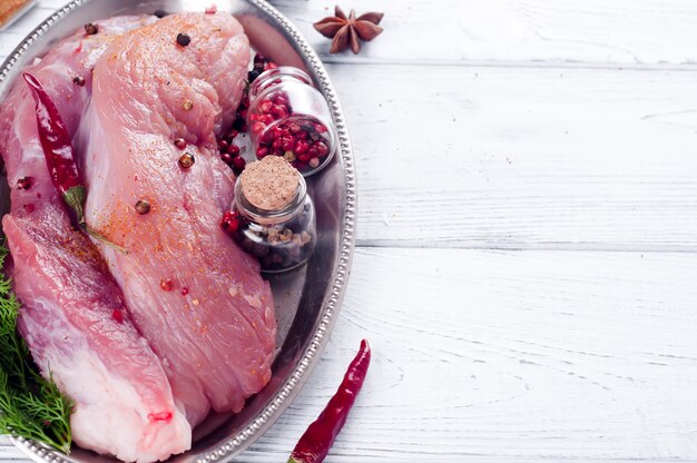 Entrecote e condimenti di bistecca di carne fresca cruda nel piatto di ferro con olio, peperoncino rosso, spezie aneto