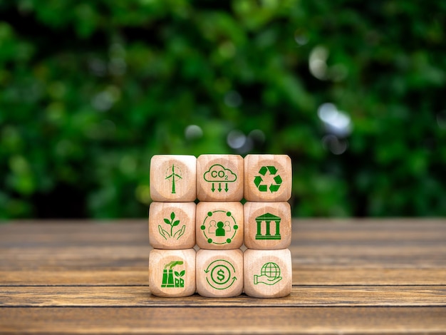 Environmental social and corporate governance ESG environment sustainable for save the earth concept ESG element icons on wooden cube blocks stack on wood table and green plant background