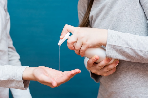 Epidemia di covid19. Concetto di trattamento delle mani con un disinfettante. I bambini si aiutano a vicenda.