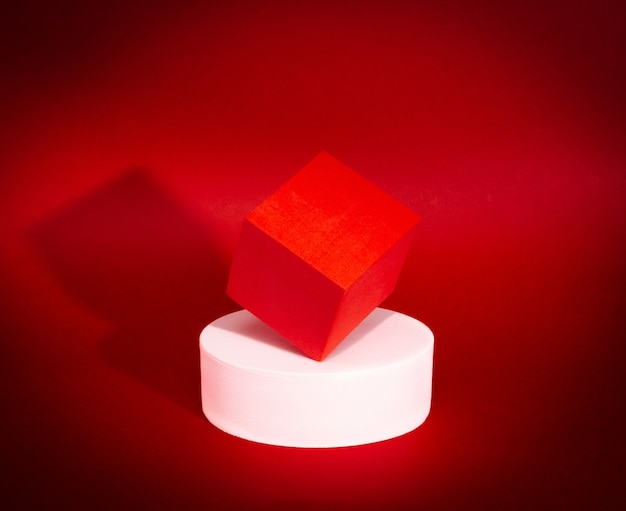 Equilibrio luminoso di cubo rosso e cerchio bianco