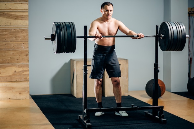 Equipaggi fare una pausa un supporto di sicurezza del bilanciere in una palestra