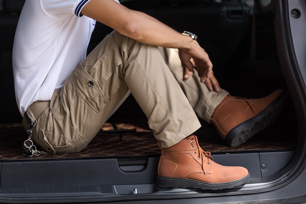 Equipaggi i pantaloni da carico d&#39;uso che si siedono nel parcheggio dell&#39;automobile di suv nel parco naturale