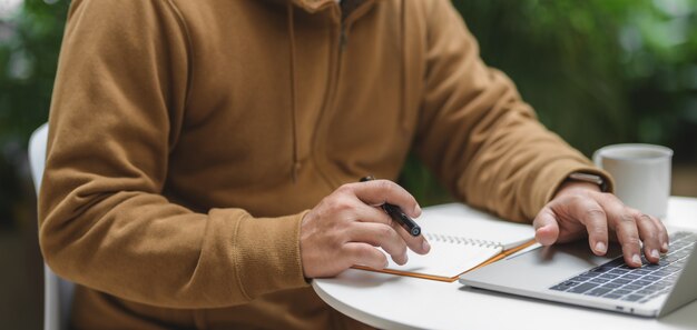 Equipaggi il lavoro con il computer portatile nel posto di lavoro comodo all'aperto