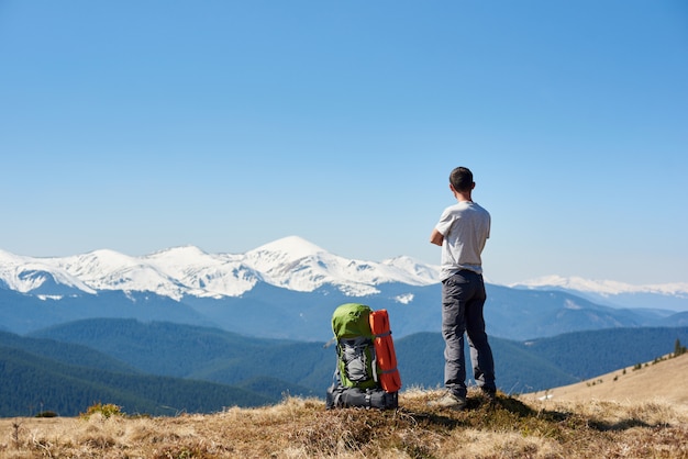 Equipaggi il riposo in cima alla montagna dopo l'escursione godendo della vista sbalorditiva delle montagne nevose