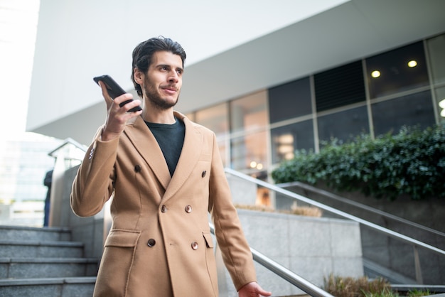 Equipaggi la conversazione sul telefono mentre camminano giù una scala