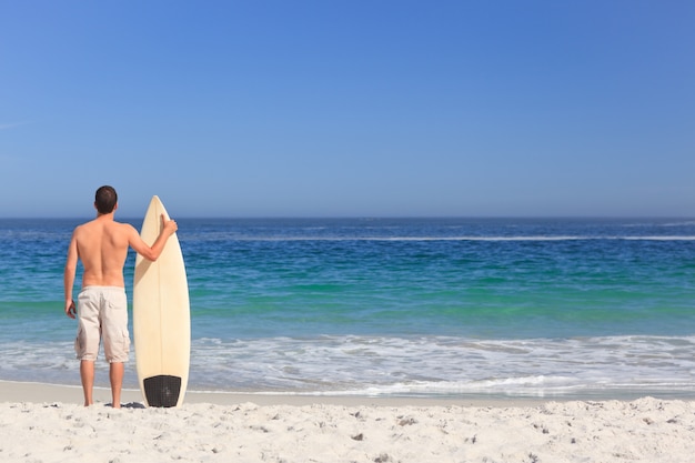 Equipaggi la sua tavola da surf sulla spiaggia