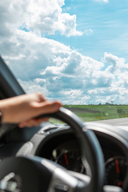 Equipaggi le mani sullo spazio della copia della giornata di sole nuvolosa del volante