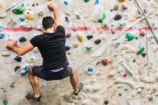 Equipaggi praticare la scalata di roccia sulla parete artificiale all&#39;interno. Stile di vita attivo e concetto di bouldering.