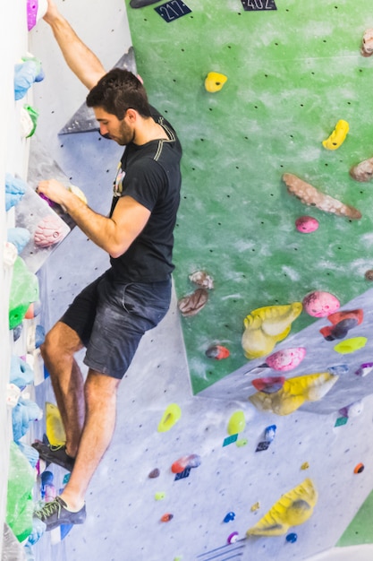 Equipaggi praticare la scalata di roccia sulla parete artificiale all&#39;interno. Stile di vita attivo e concetto di bouldering.